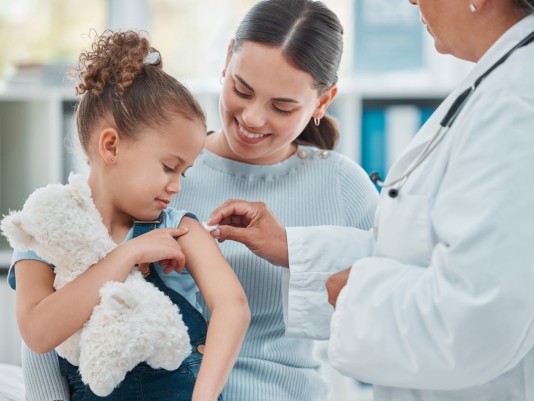 kleines Mädchen mit Mutter beim Impfen