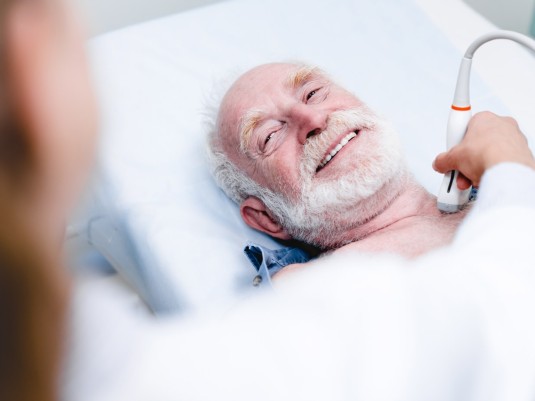 Senior beim Ultraschall am Hals